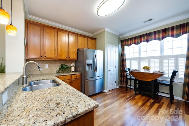 kitchen featuring stainless steel fridge with ice dispenser, decorative light fixtures, tasteful backsplash, and light stone counters