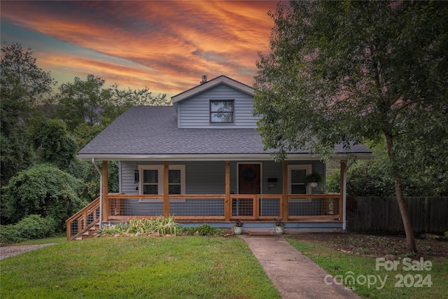 view of front of home with a lawn and a porch