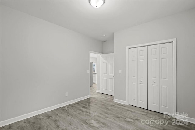 unfurnished bedroom featuring light wood-type flooring and a closet