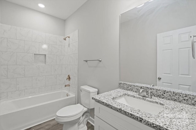 full bathroom featuring tiled shower / bath, toilet, vanity, and hardwood / wood-style flooring