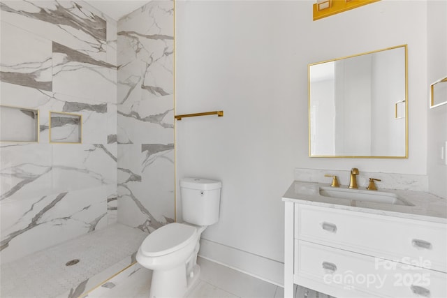 bathroom featuring vanity, toilet, and a tile shower