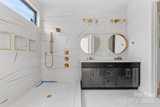 bathroom with a tile shower and vanity