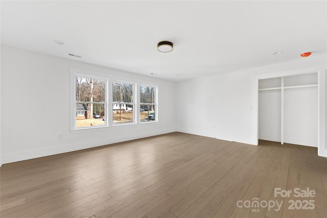 unfurnished bedroom with hardwood / wood-style floors and a closet