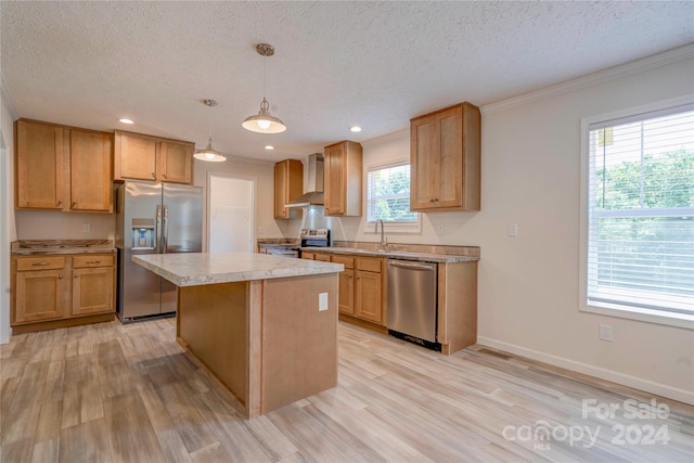 kitchen featuring appliances with stainless steel finishes, hanging light fixtures, wall chimney range hood, a textured ceiling, and a kitchen island