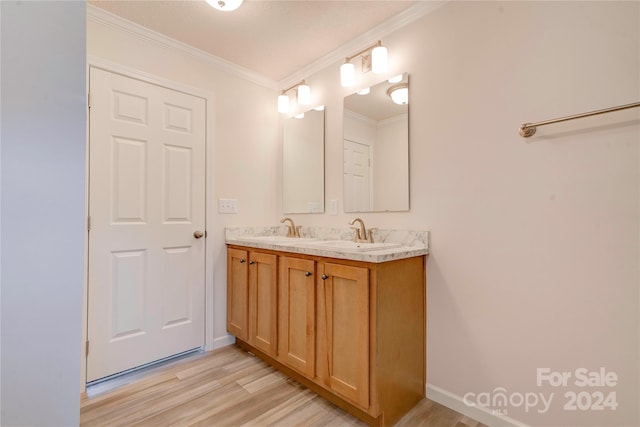 bathroom with crown molding, wood-type flooring, and vanity