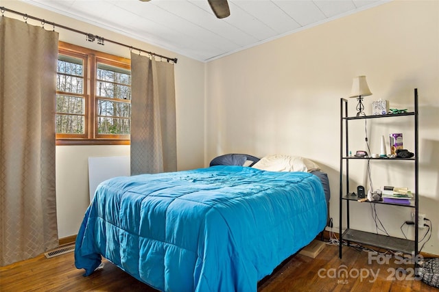 bedroom featuring crown molding, ceiling fan, and dark hardwood / wood-style flooring