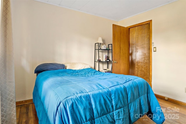 bedroom with crown molding and hardwood / wood-style flooring