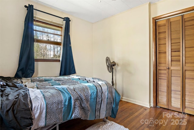 bedroom featuring ornamental molding, dark hardwood / wood-style floors, and a closet