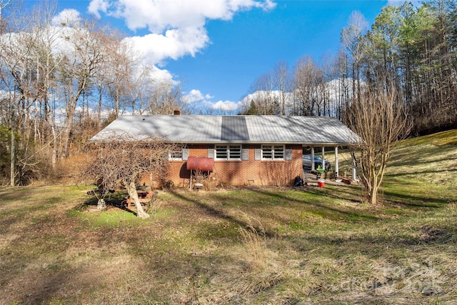 rear view of property featuring a lawn