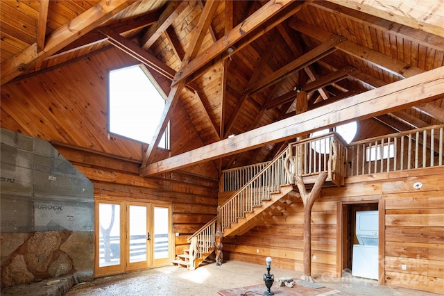 unfinished attic with stacked washer and clothes dryer