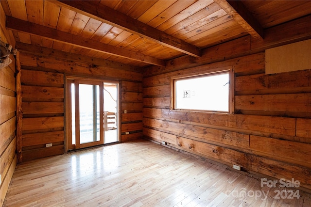 unfurnished room with wood ceiling, rustic walls, light wood-type flooring, and beamed ceiling