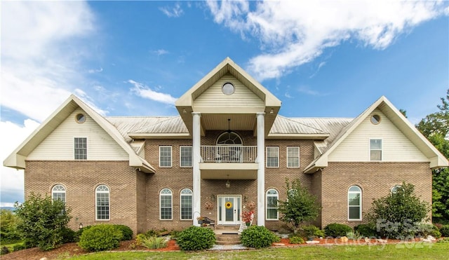 view of front facade with a front lawn and a balcony