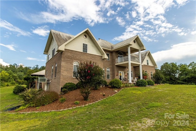 view of front of property with a balcony and a front yard