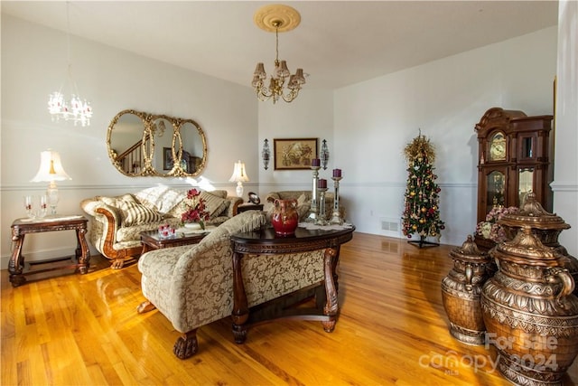 living room with an inviting chandelier and light hardwood / wood-style floors