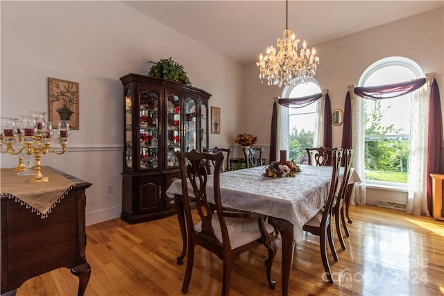 dining room with an inviting chandelier and light hardwood / wood-style flooring