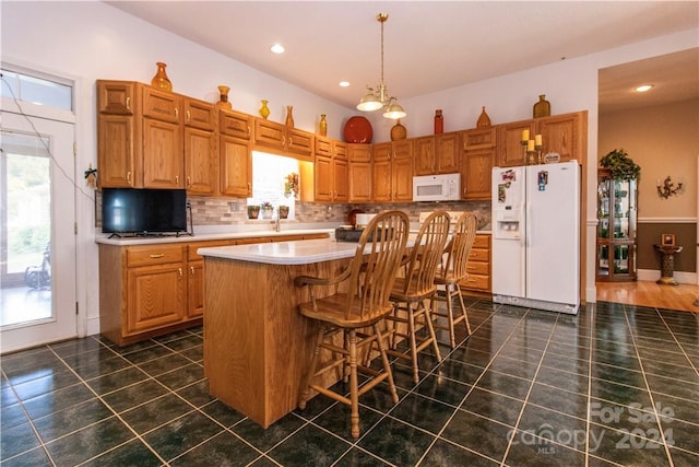 kitchen with white appliances, plenty of natural light, and a center island