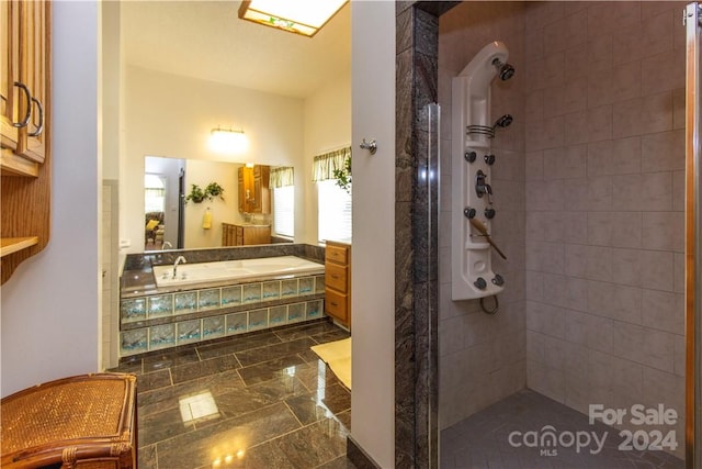 bathroom featuring tile flooring, independent shower and bath, and vanity with extensive cabinet space