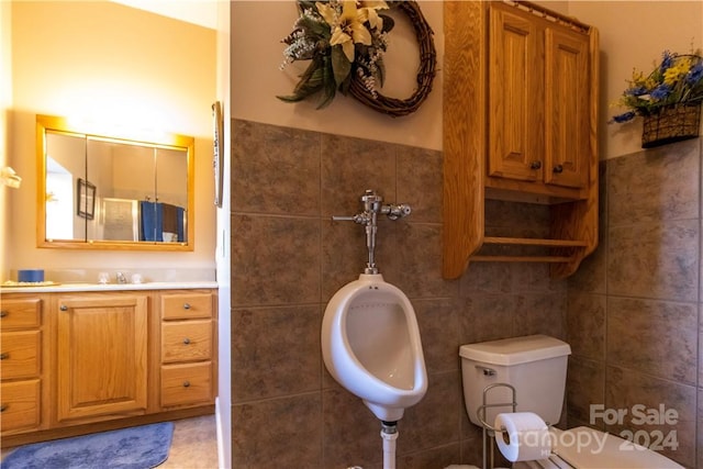 bathroom with tile walls, tile floors, toilet, and sink