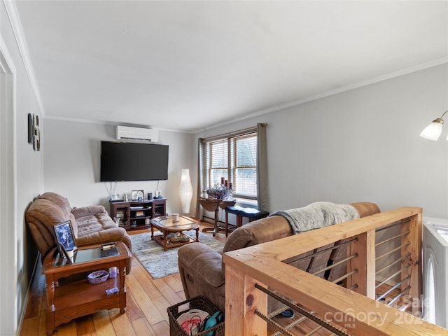 living room with washer / clothes dryer, an AC wall unit, ornamental molding, and light wood-type flooring