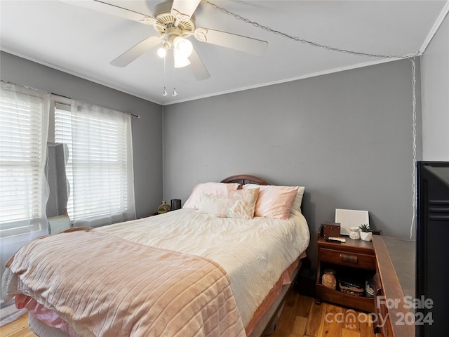 bedroom with light hardwood / wood-style flooring, ceiling fan, and ornamental molding