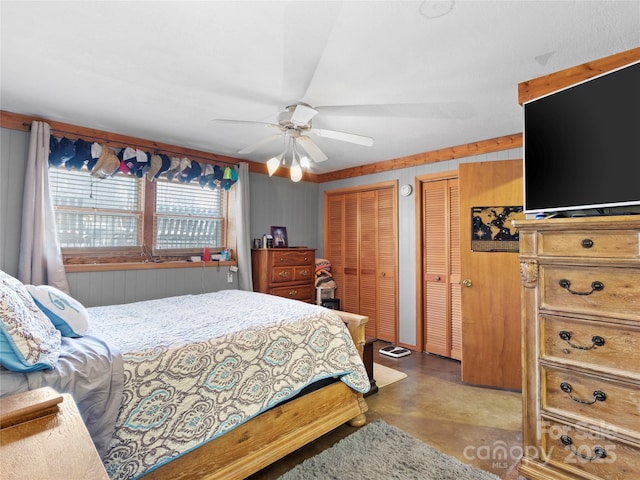 bedroom featuring multiple closets, ceiling fan, and finished concrete flooring