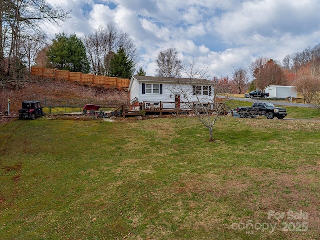 view of front of property featuring a front yard and a deck