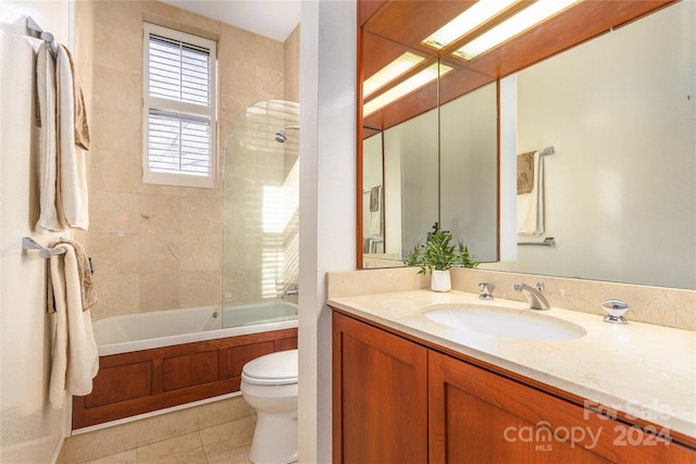 full bathroom with toilet, vanity with extensive cabinet space, tile flooring, and tiled shower / bath combo