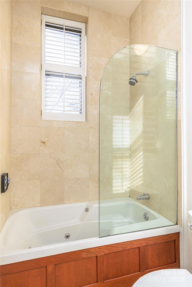 bathroom featuring toilet and tiled shower / bath