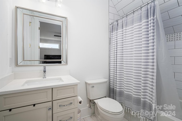 bathroom featuring vanity, curtained shower, and toilet