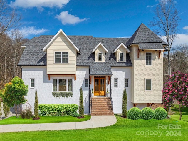 view of front of home with french doors and a front lawn