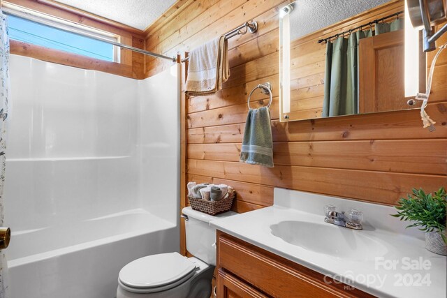 full bathroom with vanity, toilet, wooden walls, and shower / tub combo with curtain