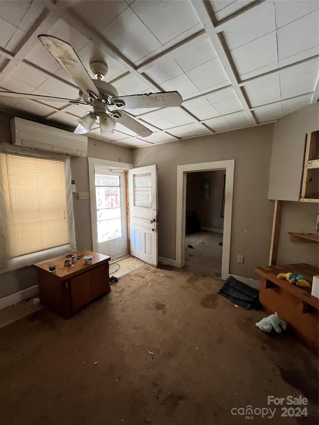 misc room featuring concrete floors, a wall mounted air conditioner, and ceiling fan