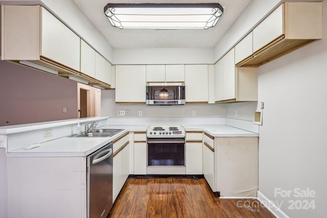 kitchen featuring white cabinets, appliances with stainless steel finishes, dark hardwood / wood-style floors, and sink