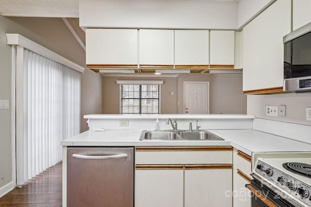 kitchen featuring lofted ceiling, white cabinetry, dark wood-type flooring, sink, and stainless steel appliances