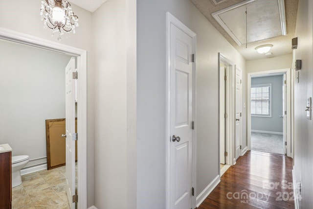 corridor featuring an inviting chandelier, a textured ceiling, and light tile floors