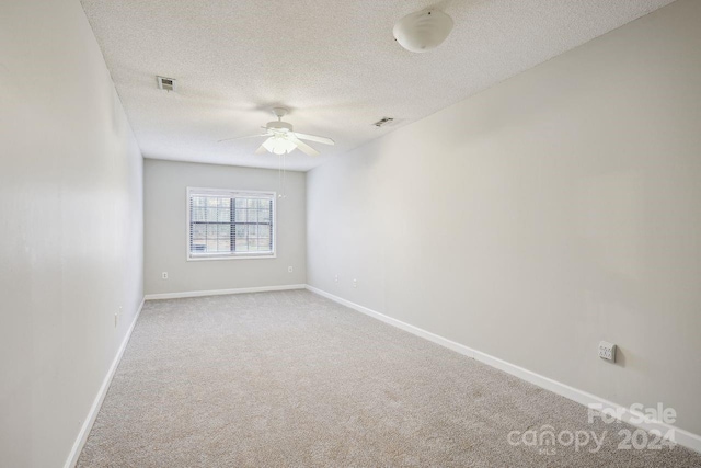 spare room with light carpet, a textured ceiling, and ceiling fan