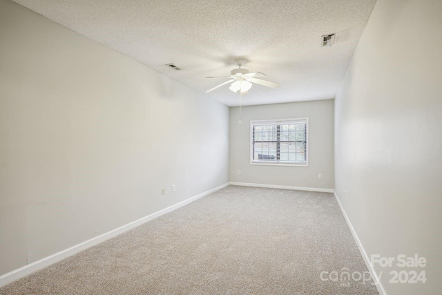 carpeted spare room with a textured ceiling and ceiling fan