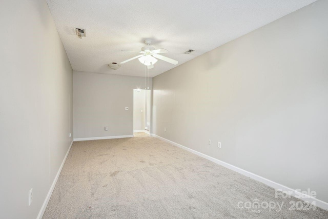 spare room with light carpet, a textured ceiling, and ceiling fan