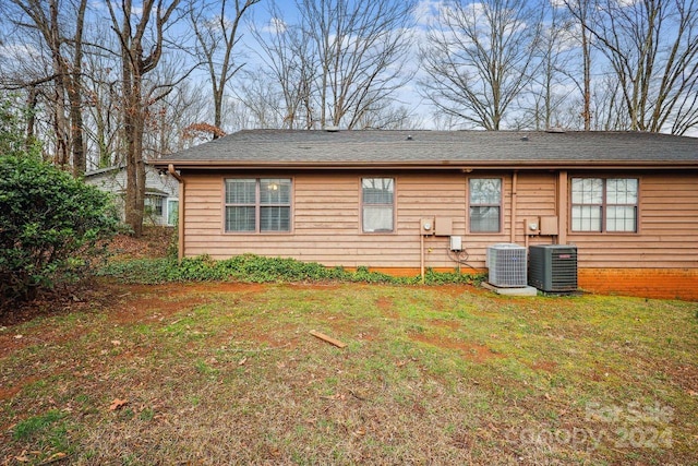 back of property with a yard and central air condition unit