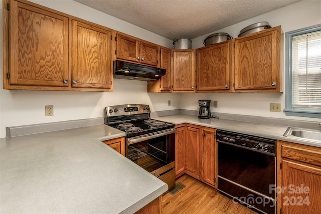 kitchen featuring light hardwood / wood-style floors, electric range, dishwasher, a textured ceiling, and sink