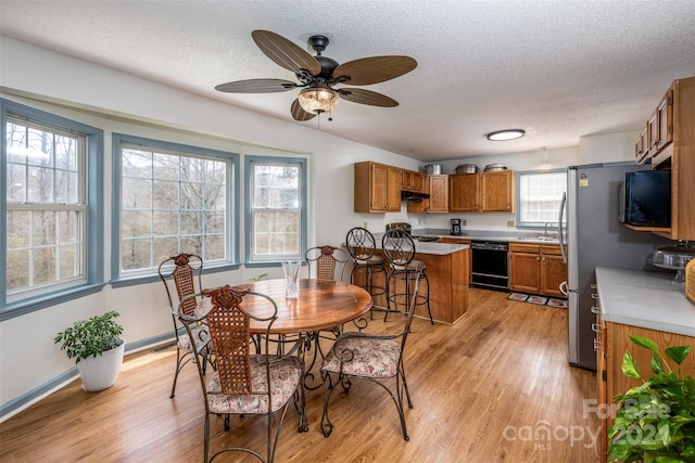 dining room with ceiling fan, a wealth of natural light, and light hardwood / wood-style floors