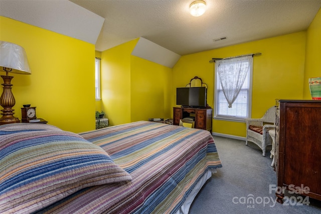 carpeted bedroom featuring a textured ceiling and vaulted ceiling