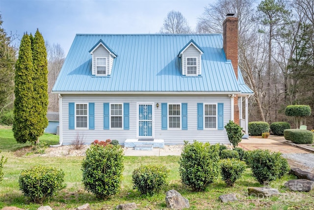 view of front facade featuring metal roof, a front yard, and a chimney