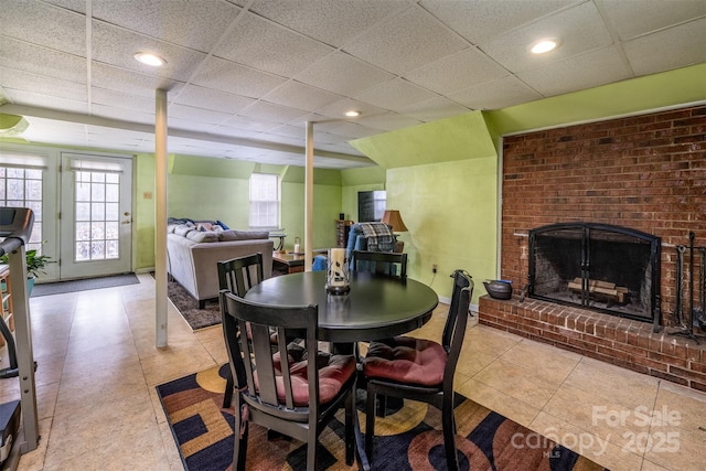 dining room with recessed lighting, a drop ceiling, baseboards, and a fireplace