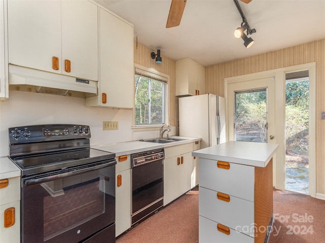 kitchen featuring ceiling fan, black appliances, sink, light carpet, and a kitchen island