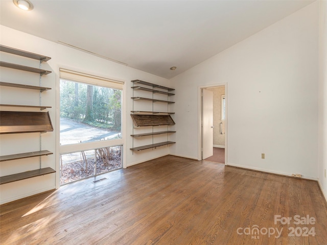 unfurnished room featuring dark hardwood / wood-style floors and lofted ceiling