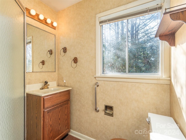 bathroom featuring a wealth of natural light, toilet, and vanity