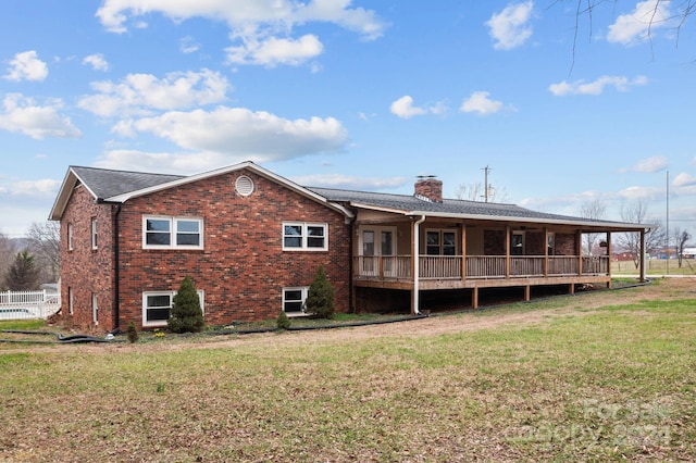 rear view of house featuring a lawn