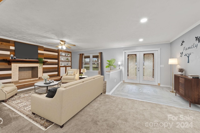 carpeted living room featuring ceiling fan, a brick fireplace, a textured ceiling, ornamental molding, and french doors