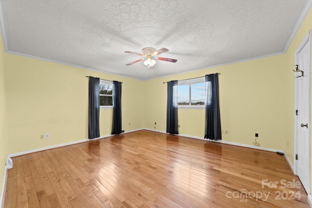 spare room with ceiling fan, a textured ceiling, light hardwood / wood-style flooring, and ornamental molding